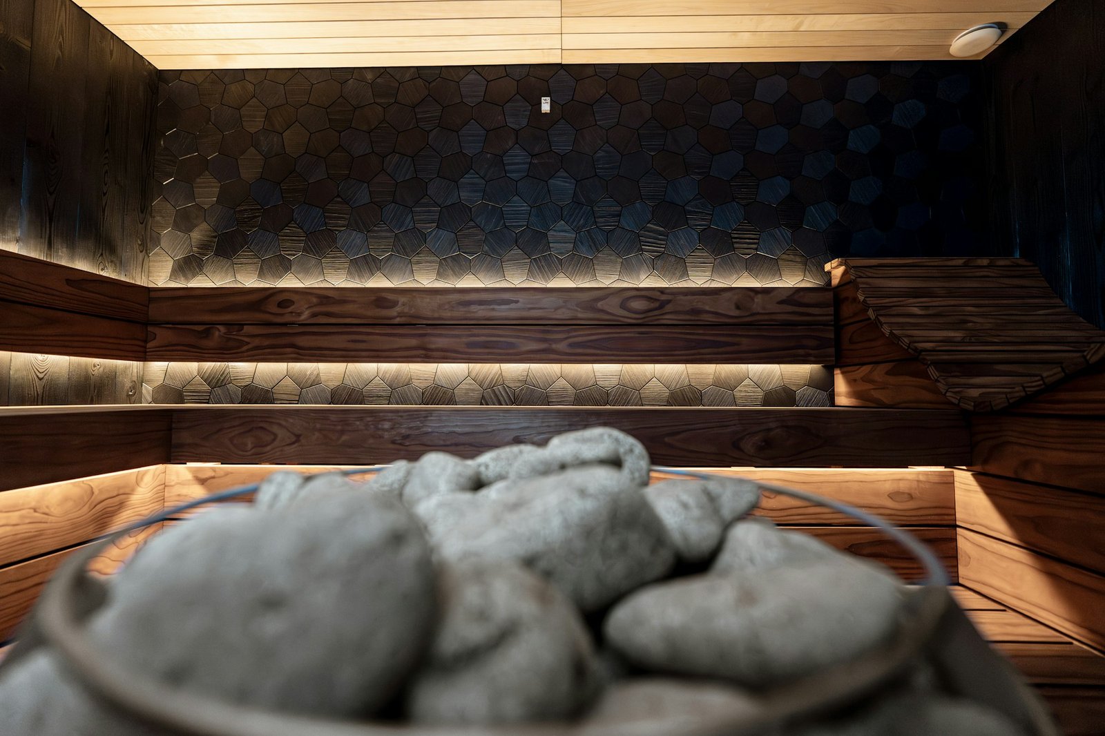 Pierres empilées dans une vasque, détail d'un sauna.
