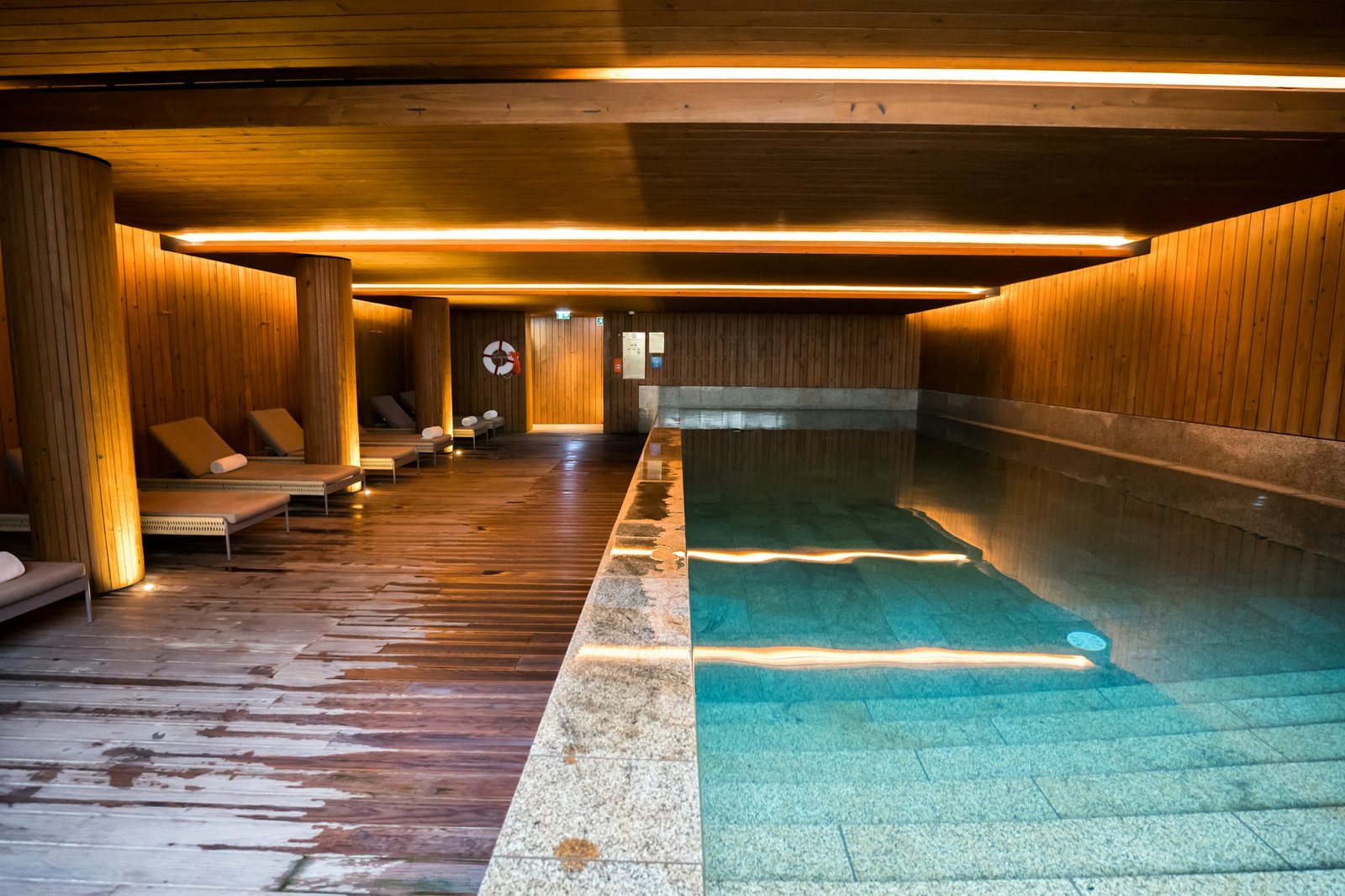 Bassin intérieur bordé d'assises basses, dans une lumière tamisée.