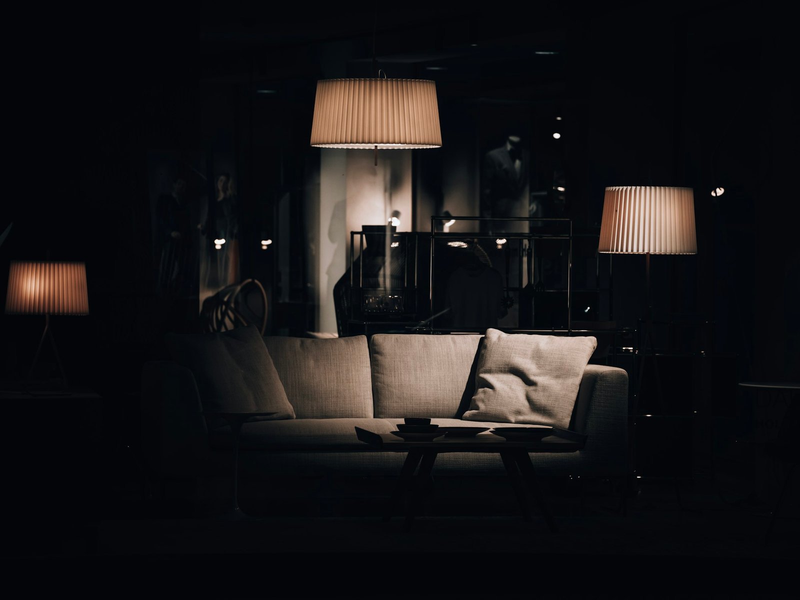 Espace de repos très sombre, assises basses et lampes chaudes.