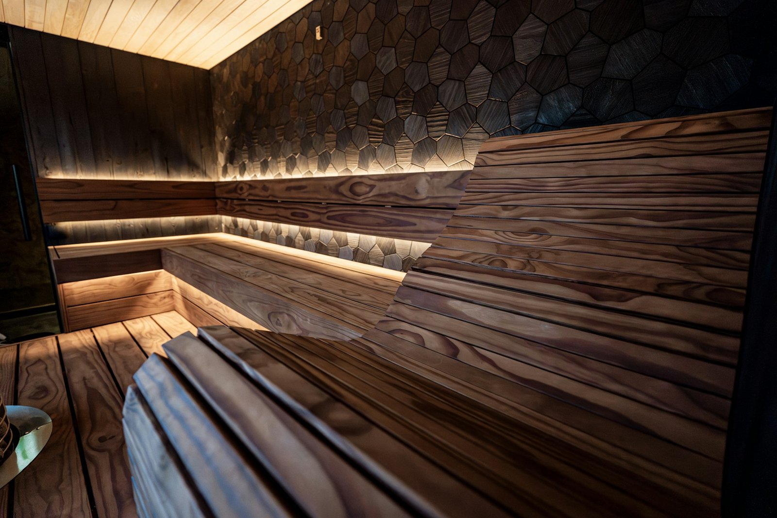 Banquettes de sauna soulignées par un éclairage indirect très doux.