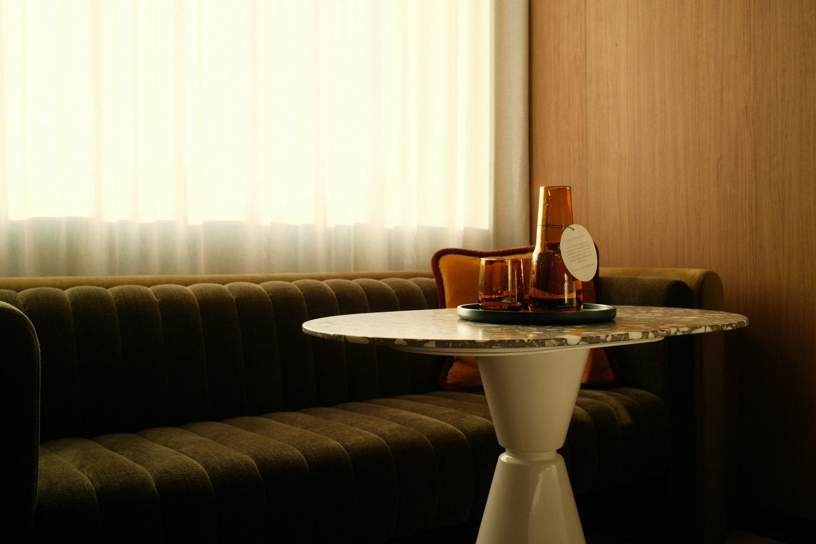 Un plateau de boissons déposé sur une table basse, près d'une banquette.